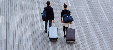 Couple travelling with luggage on wheels