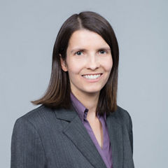 Porträt von Natascha Plank vor einer grauen Wand