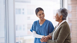 Nurse holding hands of old patient