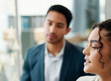 Two people collaborating at a transparent board in an office
