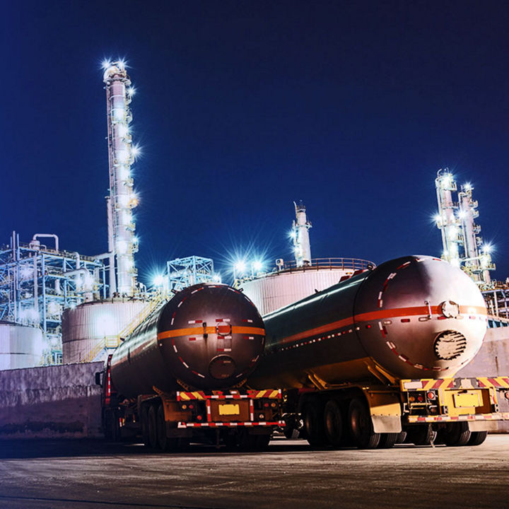 The oil truck tankers in the refinery background in the evening
