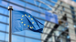 European Union flags in front of the blurred European Parliament in Brussels, Belgium