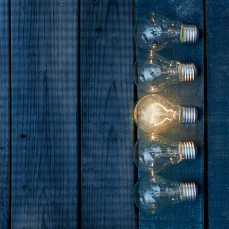 Five electric lamps on table; one of them is glowing