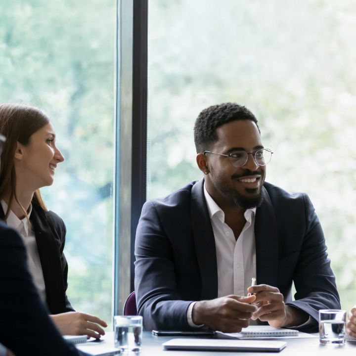 People sat around an office table talking