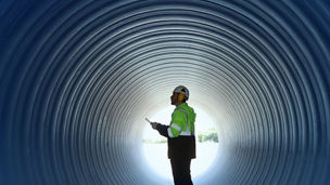A worker in a tunnel wearing ear defenders