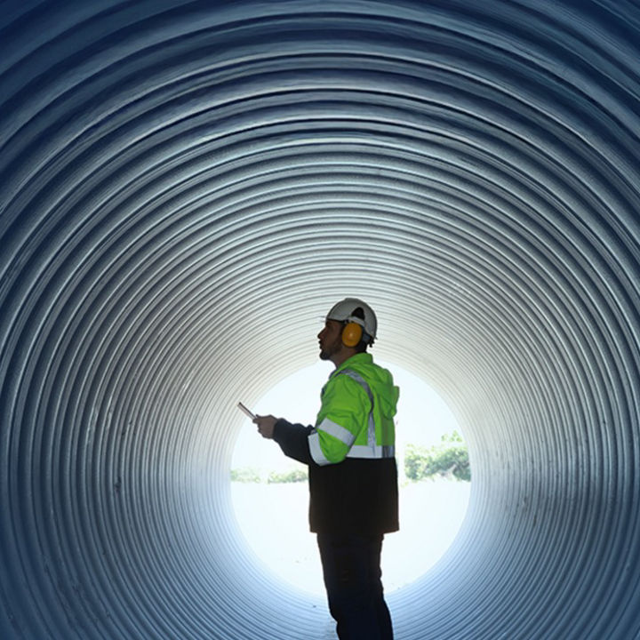 A worker in a tunnel wearing ear defenders