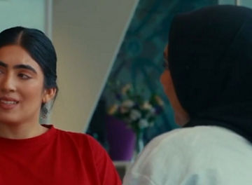 Two people in conversation whilst stood in a KPMG office