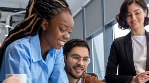 Colleagues collectively looking at a laptop