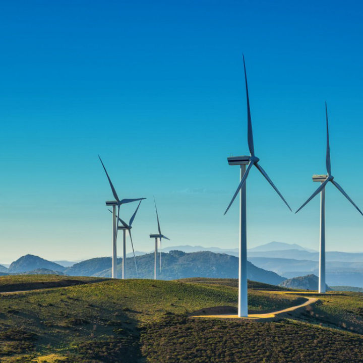 Wind turbines on a mountain with a clear blue sky background