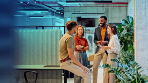 People stood around in an office in conversation