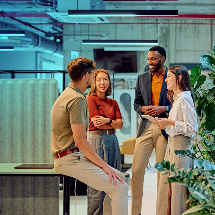 People stood around in an office in conversation