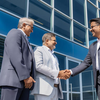 Indian Businessmen Shaking Hands Outside Office Building After Successful Deal