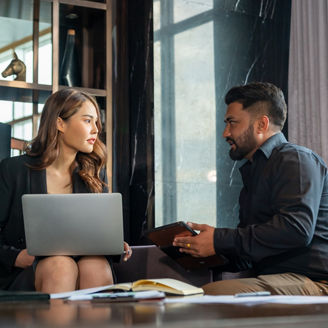 Businessman and businesswoman colleague using laptop and digital tablet working and discussion business plan at office building. Corporate business people partnership and teamwork meeting concept.