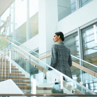 Female Worker On Stairs In Office Indoors. Business Woman In Modern Office Building. High Resolution