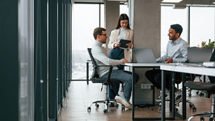 Smiling and talking. Men and woman are working in the office together.