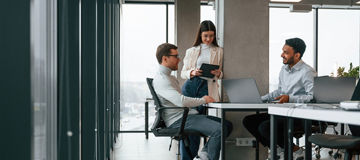 Smiling and talking. Men and woman are working in the office together.