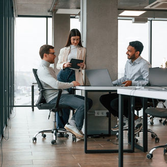 Smiling and talking. Men and woman are working in the office together.