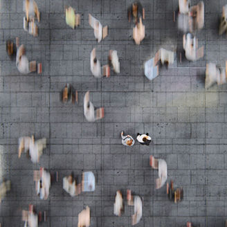 Businessman standing in the fast moving crowds of commuters. This is entirely 3D generated image.