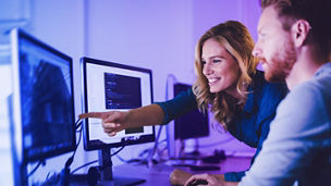 A woman and a men looking at a monitor
