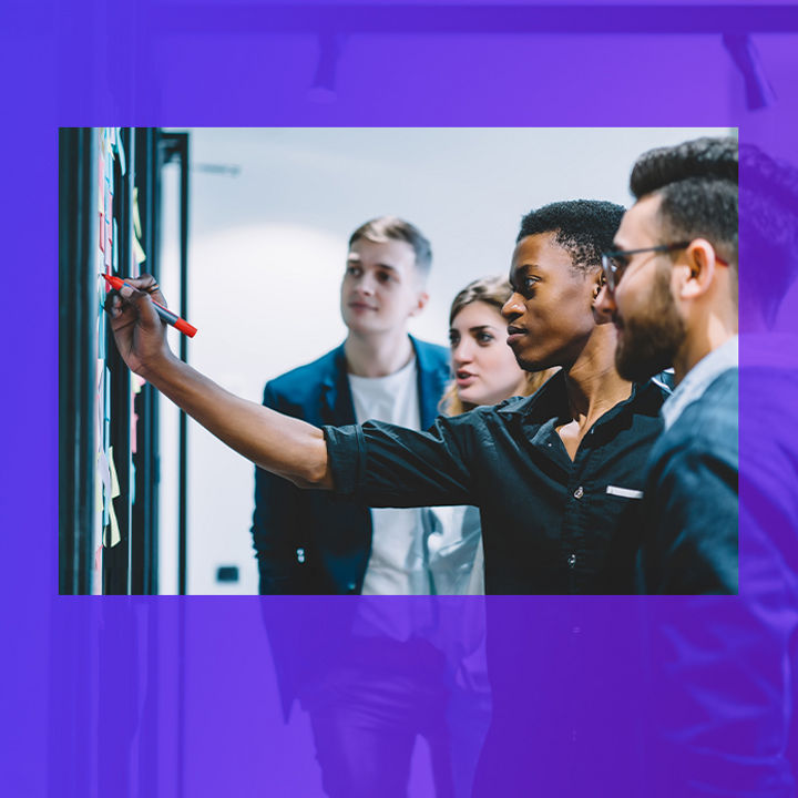 People collaborating in front of a white board banner