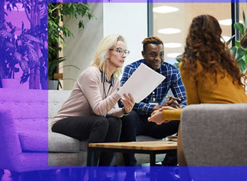 People in conversation in an open plan office space