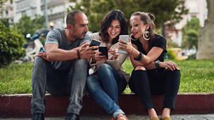 Phone, smile and travel with couple of friends outdoor in city together for sightseeing or tourism. Directions, location and search with group of people on sidewalk for adventure, holiday or vacation