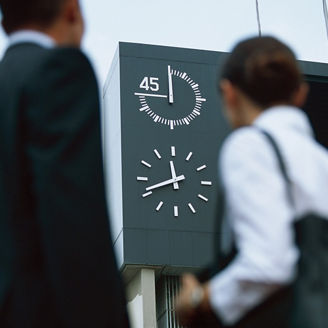 Business people looking at clock on stadium sign display