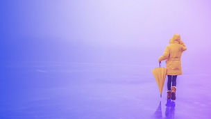 woman in yellow coat walking with yellow umbrella