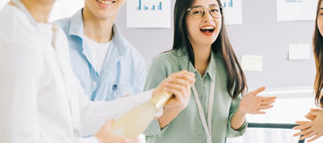 Asian businessman is opening champagne to celebrate the new year with the members of the business group