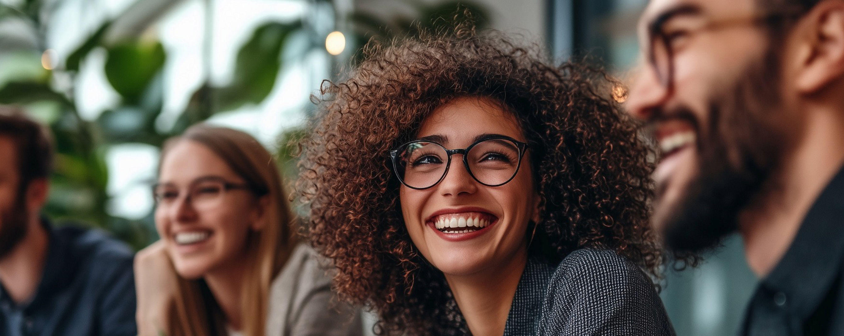 Four people smiling in an indoor office space