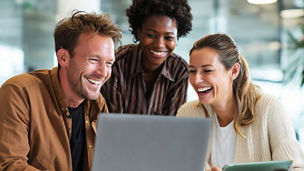 people smiling while looking at laptop