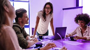 Woman in office with smiling coworkers