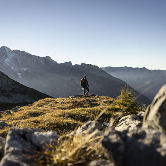 A person climbing the mountains around Watzmannhaus on a sunny day