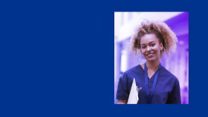 Person smiling whilst wearing healthcare scrubs with a dark blue background