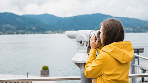 Person in yellow jacket using binoculars