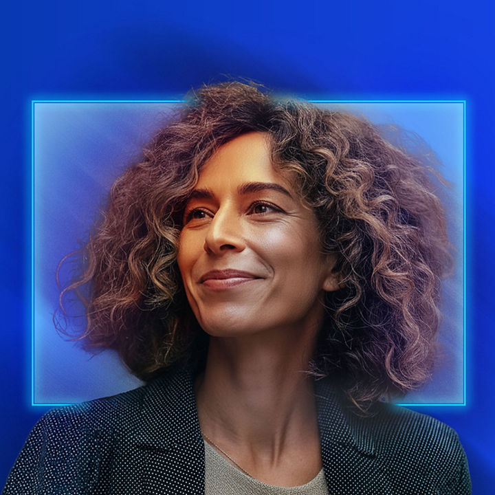 Portrait of a person with curly hair, set against a blue background with a glowing square frame around the head