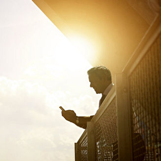 Person standing in the balcony looking at his phone