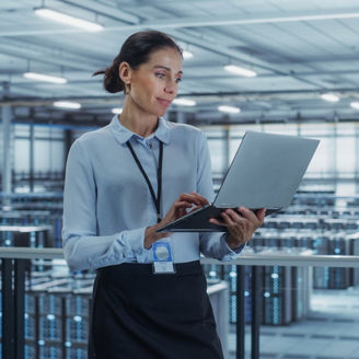 Person using laptop in datacenter