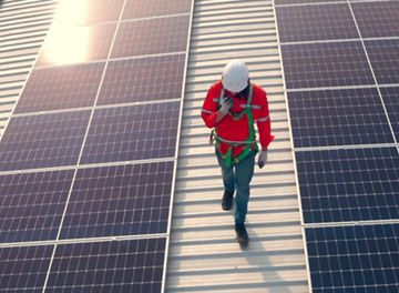 Person walking between solar panels