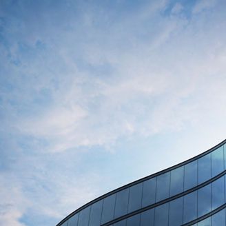 Perspective of high rise building and dark steel window system with clouds reflected on the glass.Business concept of future architecture,lookup to the angle of the building corner. 3d rendering