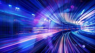 Pink, purple and blue light trails in an illuminated tunnel