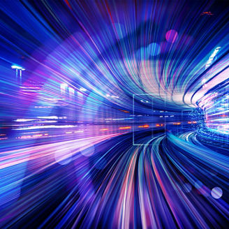 Pink, purple and blue light trails in an illuminated tunnel