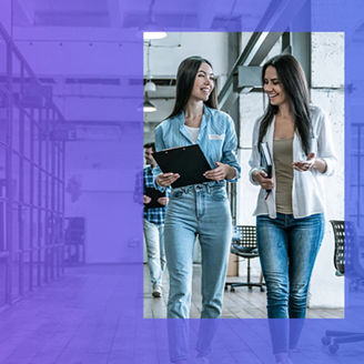 Dwie kobiety rozmawiające na korytarzu w biurze