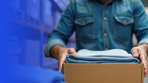 Mężczyzna niosący karton z ubraniami