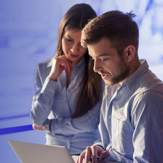 Mężczyzna i kobieta przed ekranem laptopa