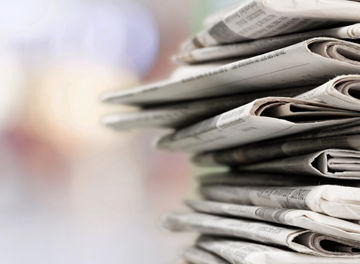 Pile of printed newspapers on background