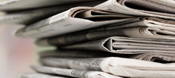 Pile of printed newspapers on background