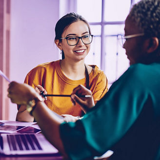 Carefree Caucasian employee in optical spectacles for provide eyes correction talking with dark skinned colleague discussing paperwork during collaborative briefing at desktop, business concept; Shutterstock ID 1958475958; purchase_order: marketing advisory assurance; job: Anne; client: AI campagne