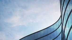 Perspective of high rise building and dark steel window system with clouds reflected on the glass.Business concept of future architecture,lookup to the angle of the building corner. 3d rendering