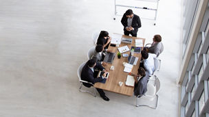 Top view of group of multiethnic busy people working in an office, Aerial view with businessman and businesswoman sitting around a conference table with blank copy space, Business meeting concept